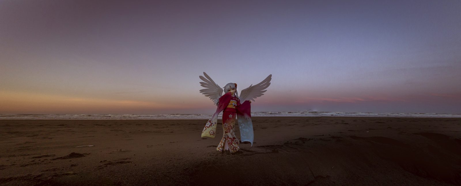 Winged figure on beach at dusk